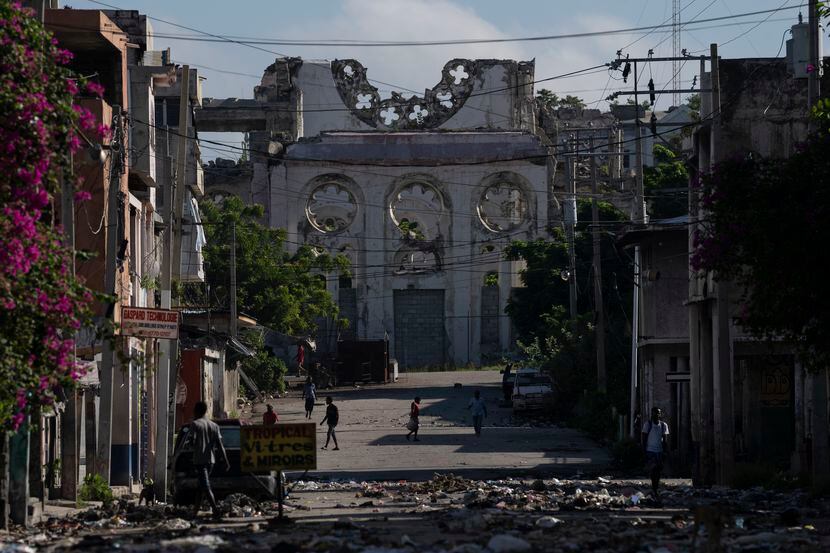 Gente camina cerca de las ruinas de la Catedral de Nuestra Señora de la Asunción destruida...