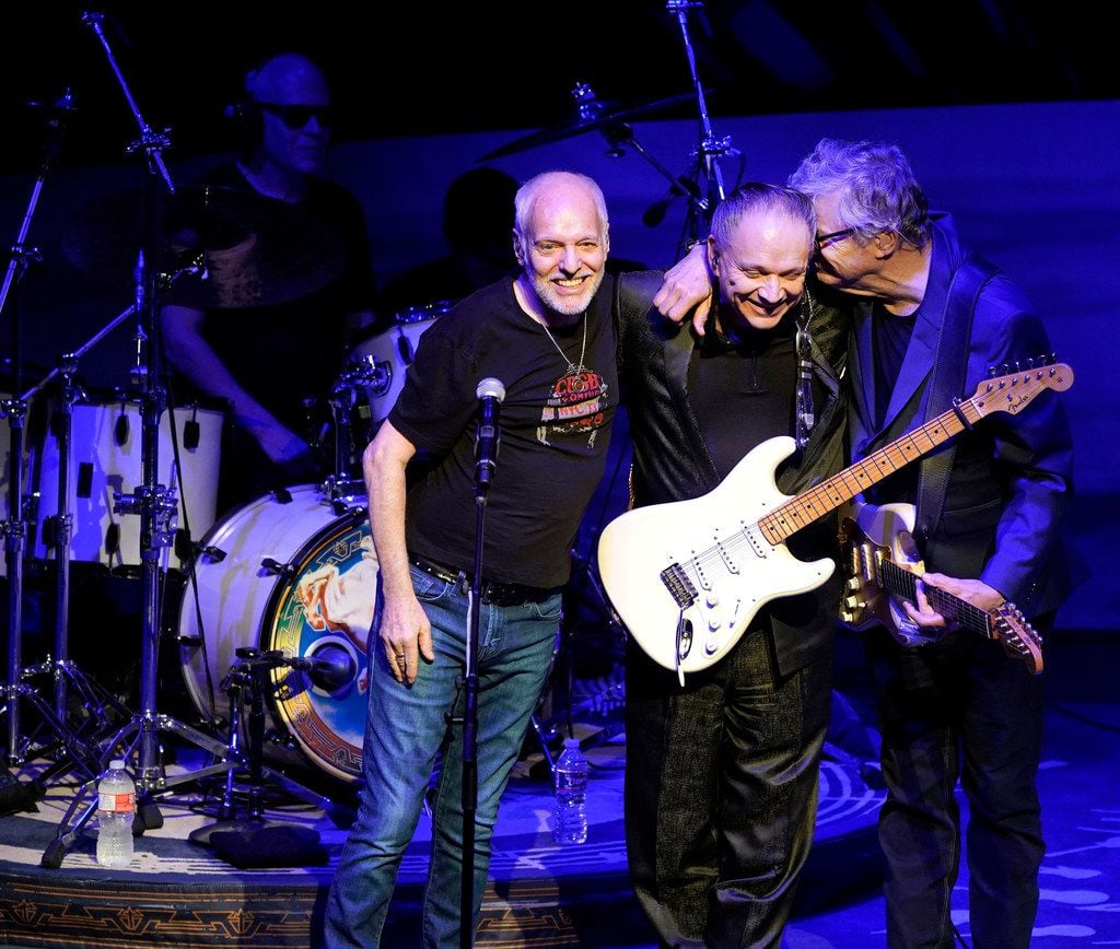 Steve Miller, right, of the Steve Miller Band, gives his long time friend Jimmie Vaughan, center, a hug after they performed several songs with Peter Frampton (left) during the Steve Miller Band concert at Austin City Limits at the Moody Theater, in Austin, Texas, July 30, 2018. 