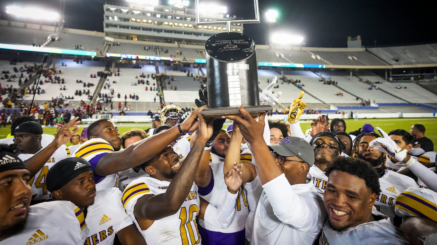 Prairie View head coach Bubba McDowell lifts the State Fair Classic trophy after a victory...