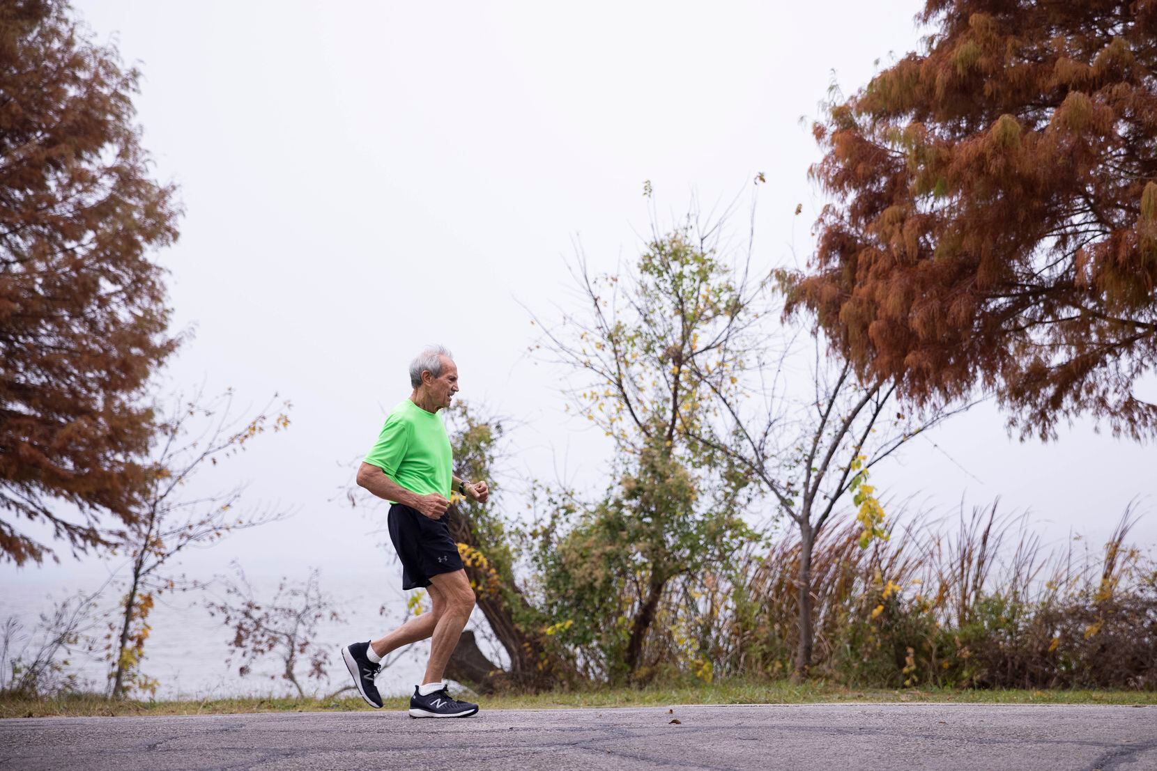 James Thruston, 84, runs during a photoshoot following his usual morning run on Friday, Dec. 3, 2021, at White Rock Lake in Dallas. (Juan Figueroa/The Dallas Morning News)