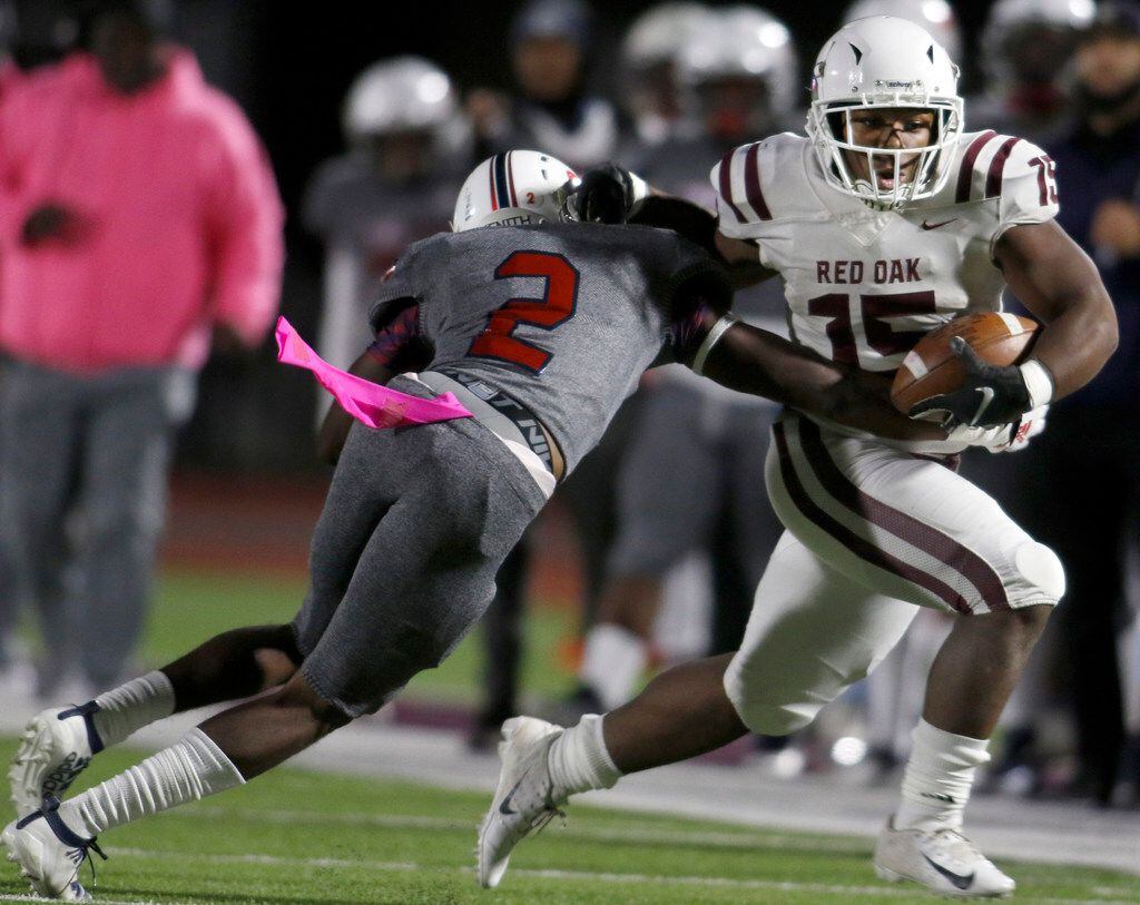 Red Oak running back C. J. Palmer (15) powers his way past the defense of Dallas Kimball...