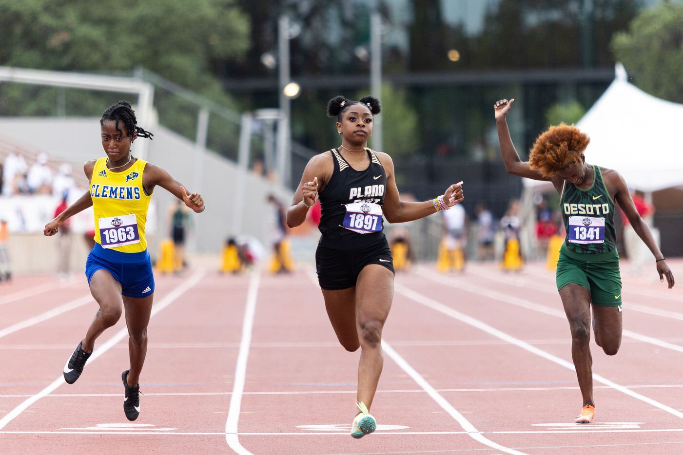 Tiriah Kelley of Plano East, center, crosses the finish in the girls' 100-meter dash at the...
