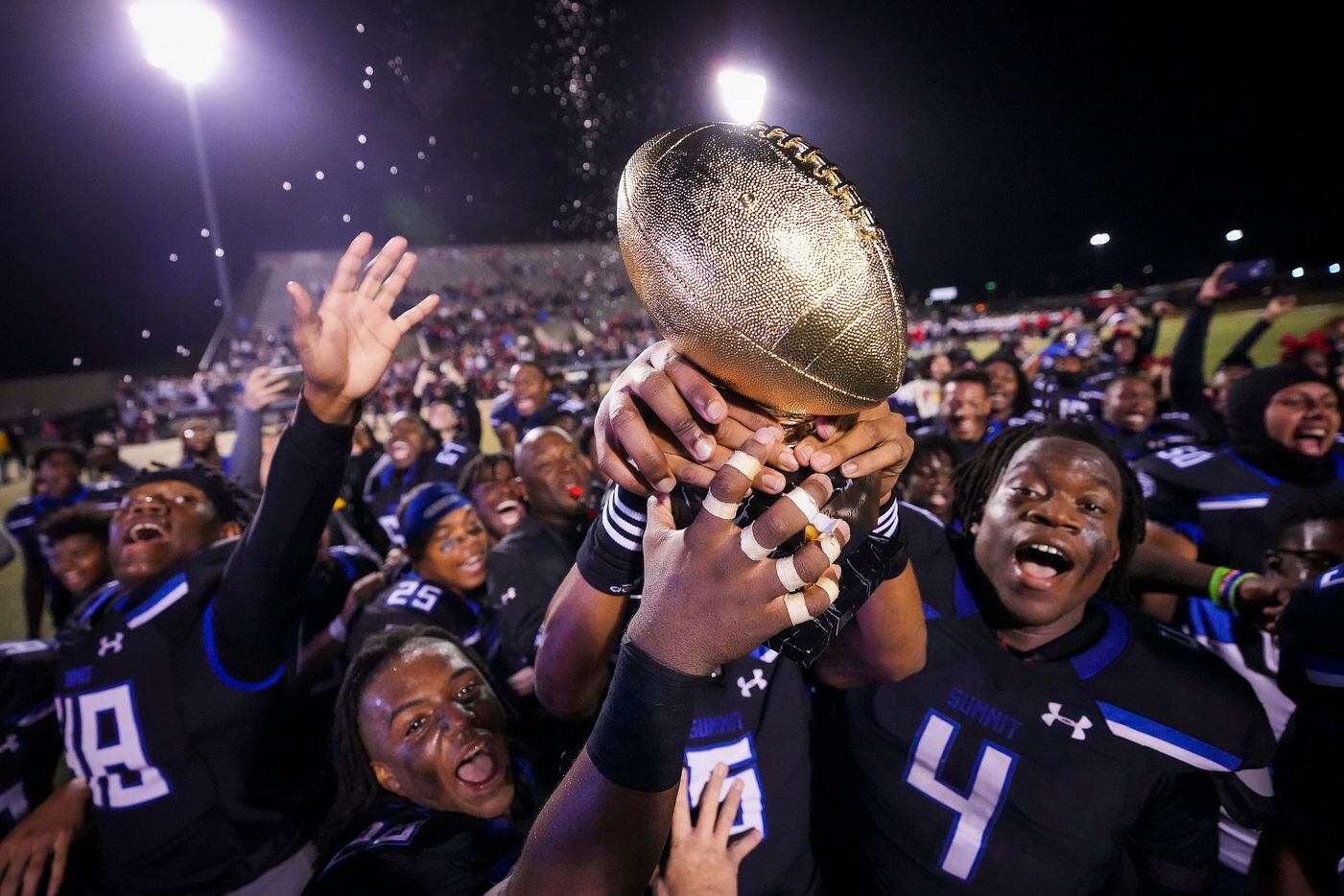 Mansfield Summit players celebrate with the game trophy after a victory over Colleyville Heritage in the Class 5A Division I Region I final on Friday, Dec. 3, 2021, in North Richland Hills, Texas. (Smiley N. Pool/The Dallas Morning News)