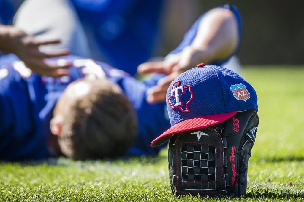 Texas Rangers pitchers stretch after a spring training workout at the team's training...