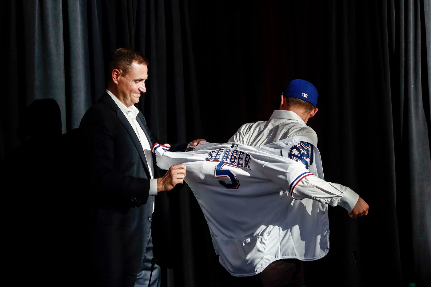 Corey Seager puts on his jersey at a news conference at Globe Life Park in Arlington on Wednesday, Dec. 1, 2021. Former Los Angeles Dodgers, Corey Seager, signed a ten year contract with the Texas Rangers for 325 million dollars. (Rebecca Slezak/The Dallas Morning News)