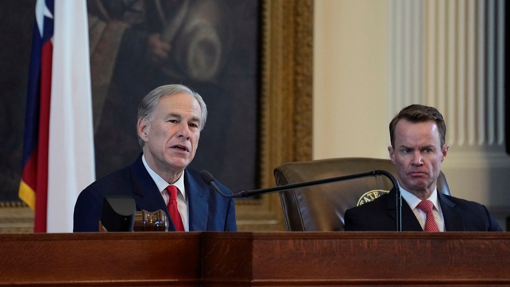 Texas Speaker of the House Dade Phelan (right) istens as Texas Gov. Greg Abbott speaks...