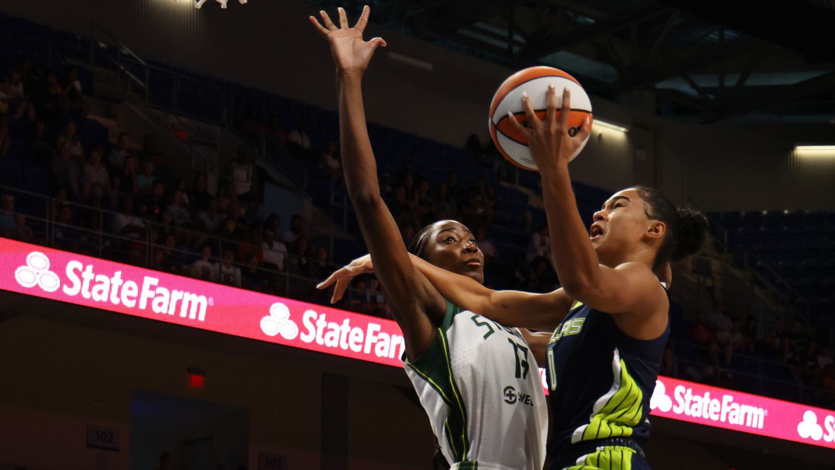 Dallas Wings forward Satou Sabally (0) drives the lane and shoots against the defense of...
