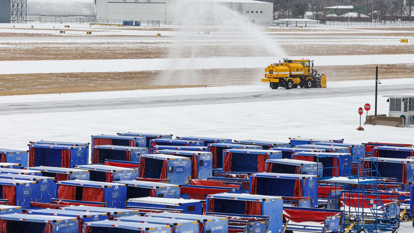 A truck removed snow from a Dallas Love Field runway on Thursday.