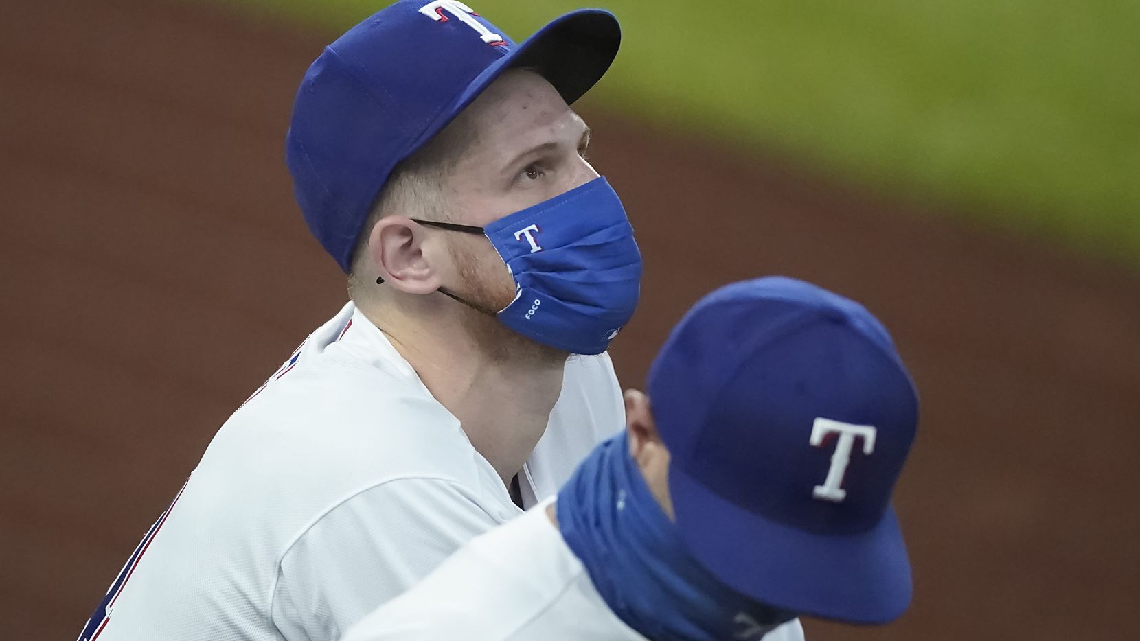 Texas Rangers catcher Sam Huff looks out over the stadium while talking with first base...