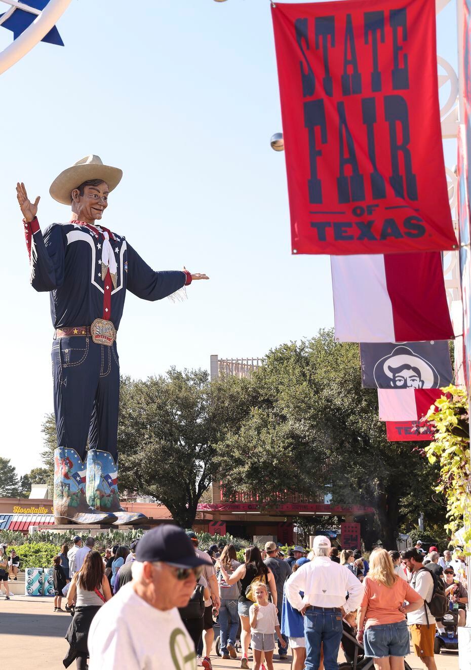 Gente camina junto al gran Big Tex, el viernes 30 de septiembre de 2022 en la Feria Estatal...