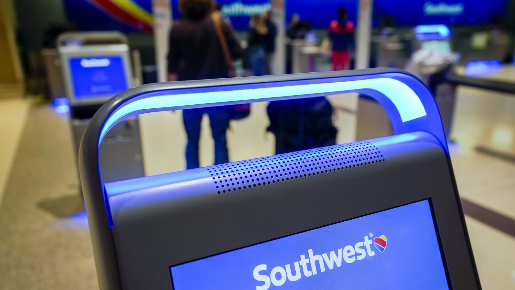 Pasajeros en la lista de espera para etiquetar su maleta y volar en Southwest Airlines,...