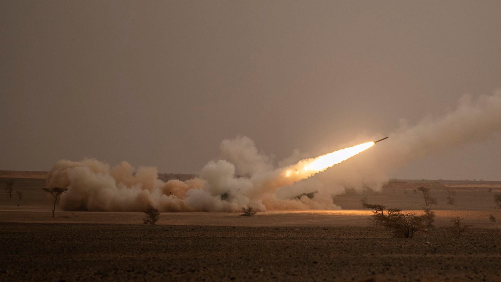 FILE - A launch truck fires the High Mobility Artillery Rocket System (HIMARS) at its...