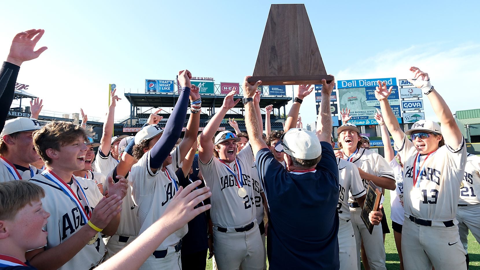 Flower Mound coach, Danny Wallace, lifts the championship trophy as he celebrates with the...