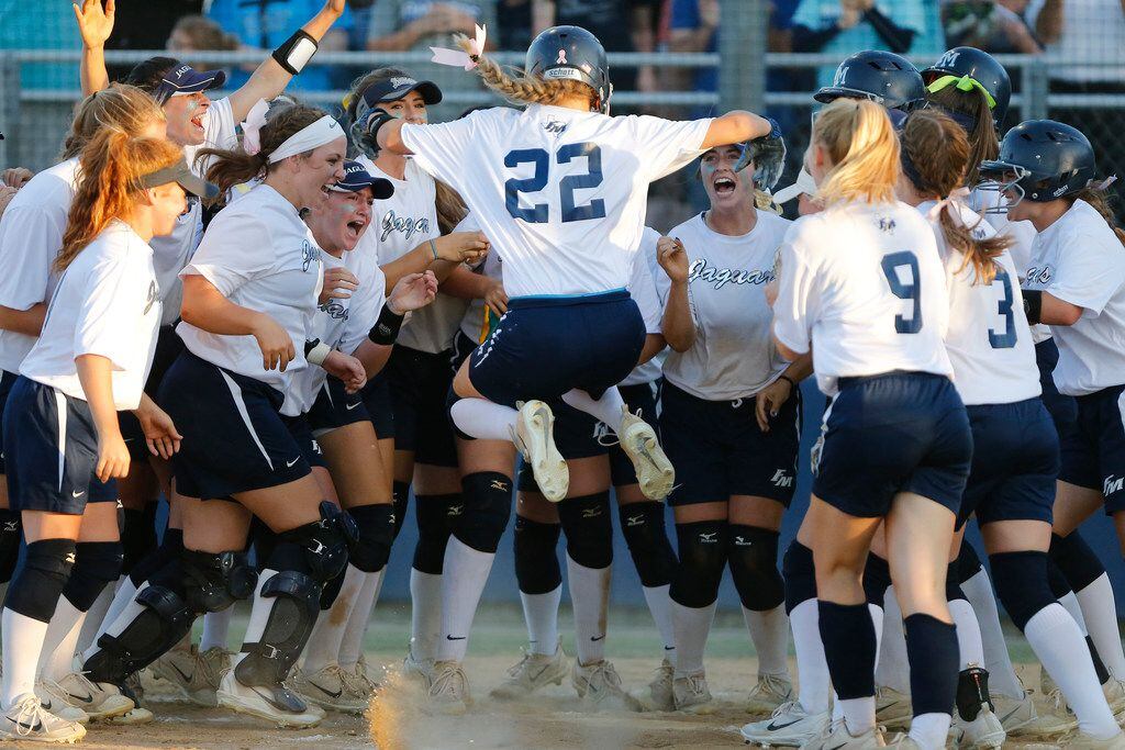 Flower Mound outfielder Maddie Carlock (22) leaps to home plate surrounded by her team after hitting a home run in the second inning as Plano Senior High School played Flower Mound High School in a one game, winner take all,  regional quarterfinal playoff softball game on Friday, May 11, 2018. (Stewart F. House/Special Contributor)