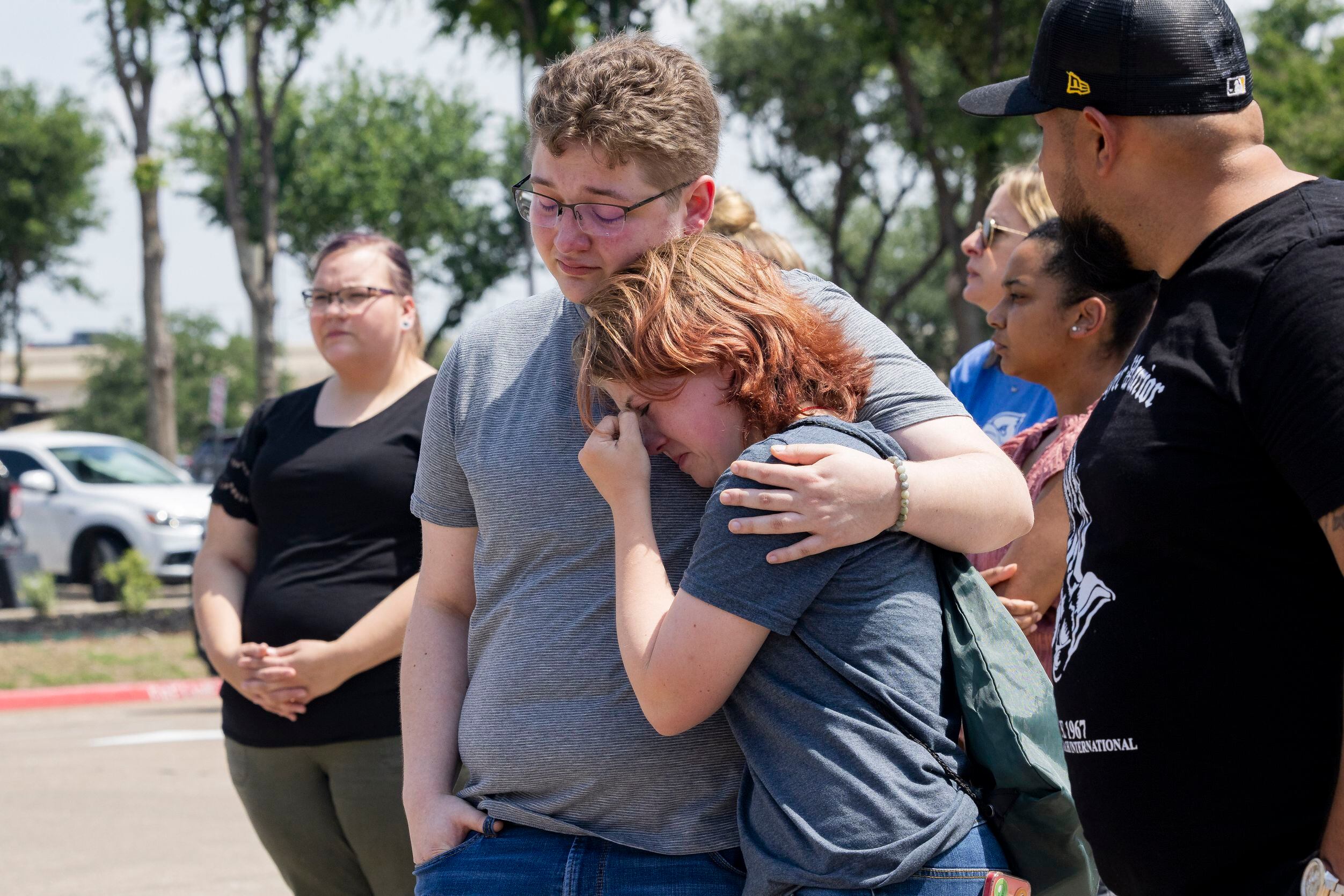 Dakota Britvich (left) and Abbi Boyd hold each other at a memorial outside the mall after a...