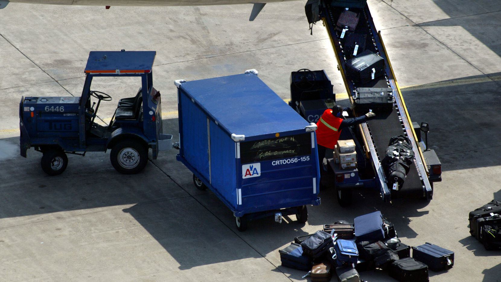 ORG XMIT: *S0405533084* Tuesday, March 11, 2003   #44340A baggage handler unloads luggage from an American Airlines flight arriving at DFW Airport.