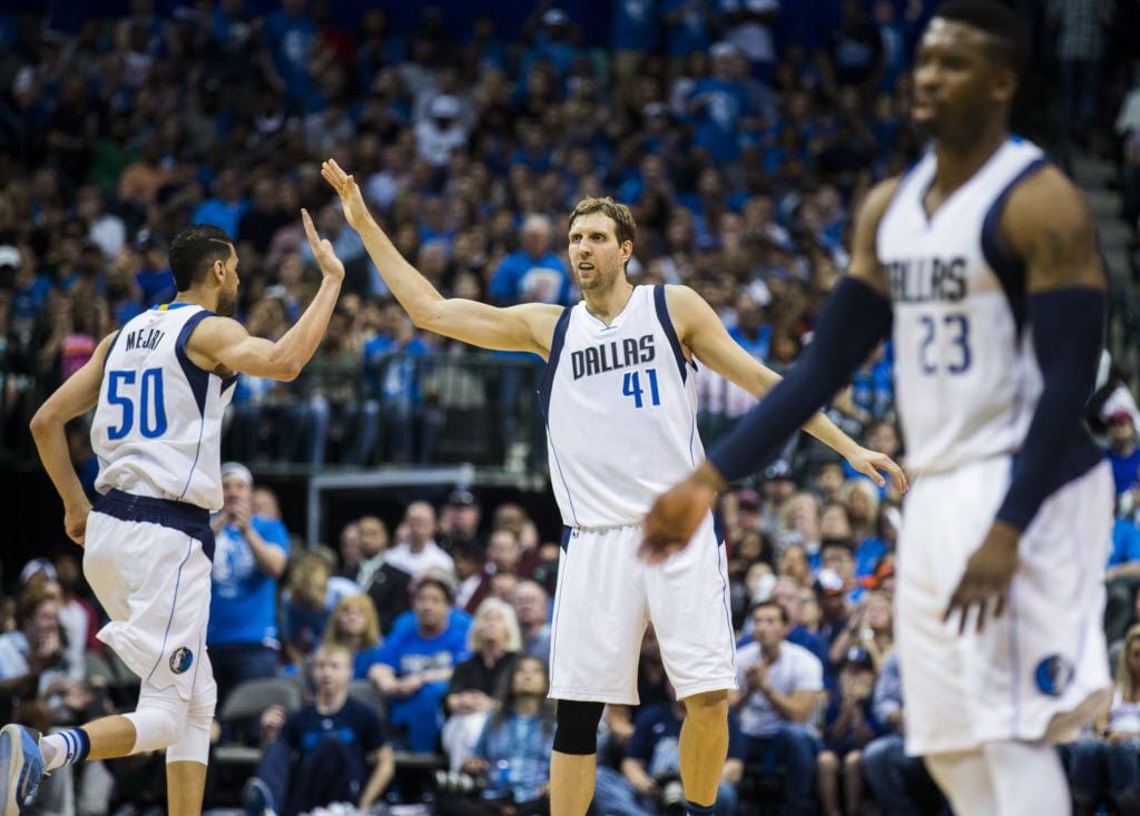 Dallas Mavericks center Salah Mejri (50) and forward Dirk Nowitzki (41) high-five during the second quarter of game 4 of their series against the Oklahoma City Thunder in the first round of NBA playoffs on Saturday, April 23, 2016 at the American Airlines Center in Dallas. At right is Dallas Mavericks guard Wesley Matthews (23). (Ashley Landis/The Dallas Morning News)