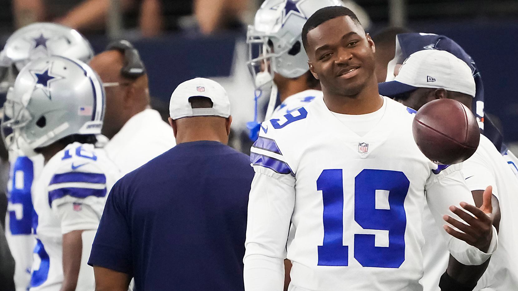 Dallas Cowboys wide receiver Amari Cooper tosses a ball on the sidelines during the first...