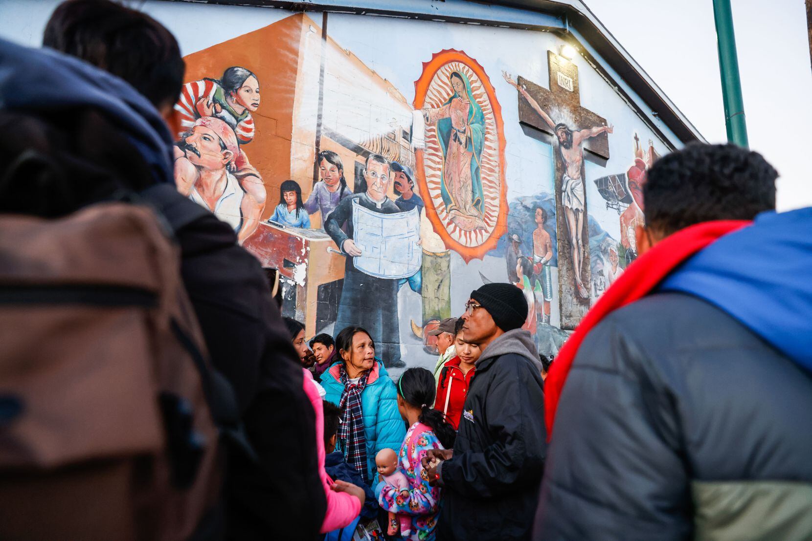 Migrants wait outside the Centro Pastoral Sagrado Corazon for an overnight stay in El Paso...