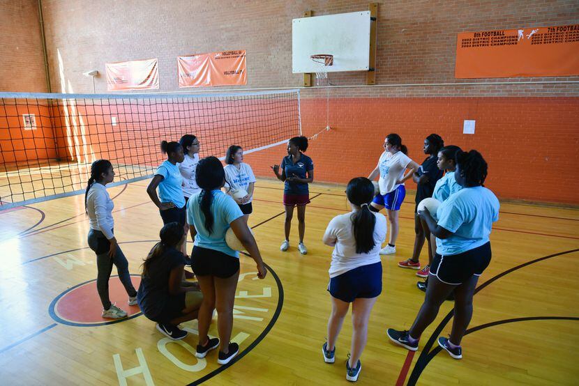 Roosevelt coach Alexandria Jackson (center) speaks with her players at the start of workouts...