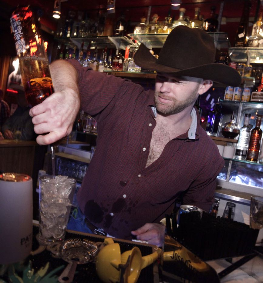 Anthony Roberts mixes drinks behind the bar at the Round-Up Saloon.