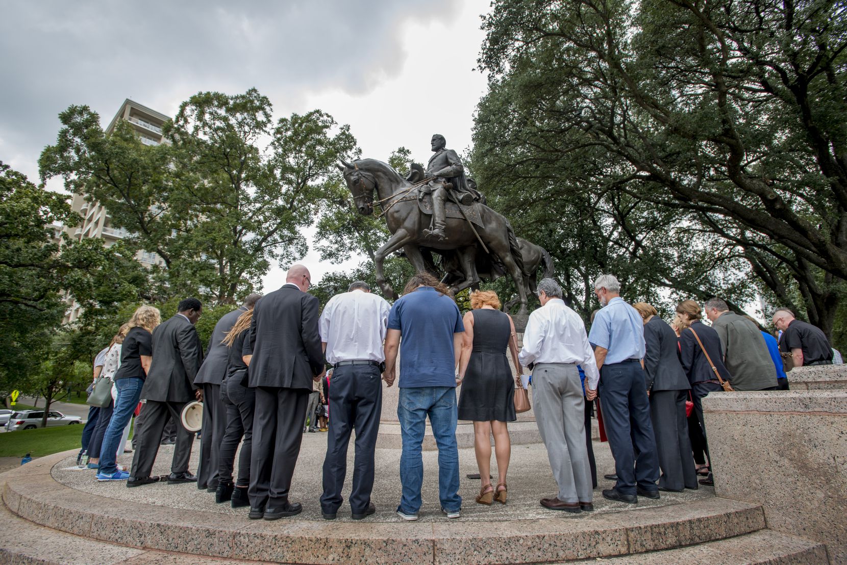 Dallas-area ministers join hands around the statue of Robert E. Lee to pray for its removal...