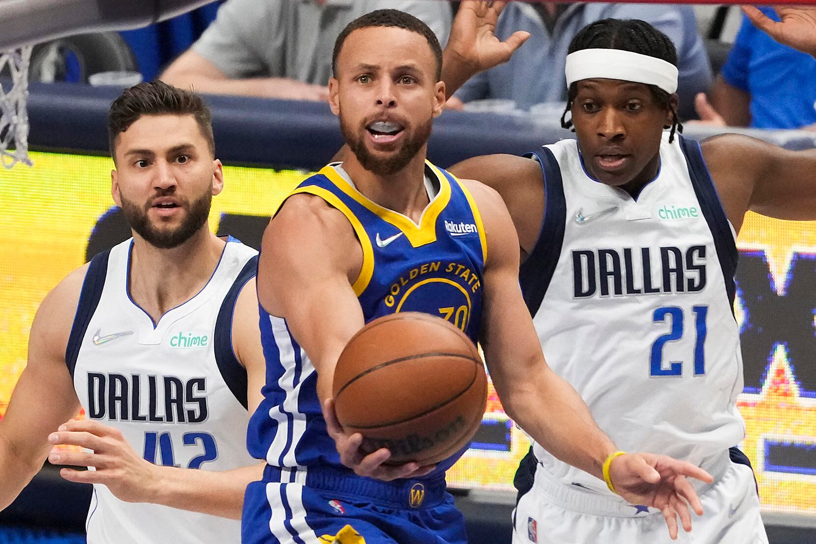 Golden State Warriors guard Stephen Curry (30) scores past Dallas Mavericks forward Maxi...