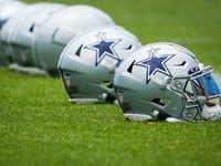 Dallas Cowboys helmets lined up on the sidelines during a minicamp practice at The Star on...