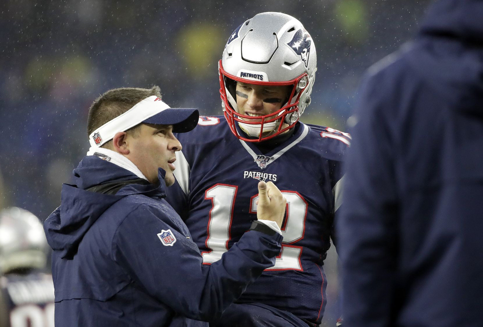 New England Patriots offensive coordinator Josh McDaniels, left, speaks to quarterback Tom...