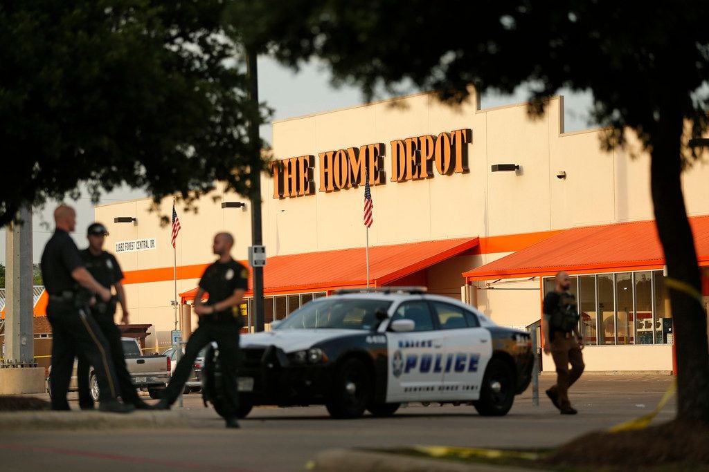 Dallas police officers stood guard Tuesday at the Home Depot where their colleagues were shot.