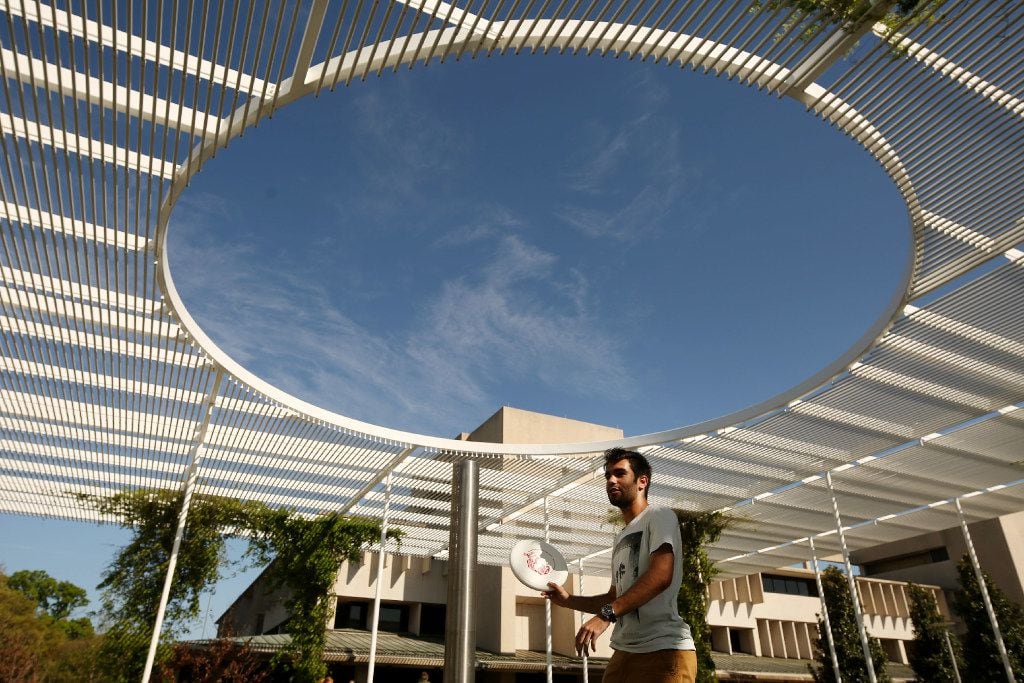 Daniel Barrios plays frisbee with other students near the student union on the campus of...