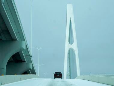 A motorist drives up an icy on ramp to the Margaret McDermott Bridge on Tuesday, Jan. 31,...
