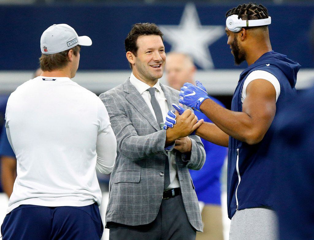 Former Dallas Cowboys quarterback and CBS sportscaster Tony Romo (center) is greeted by...