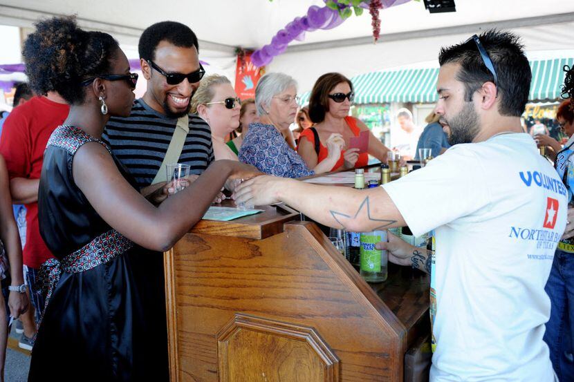 A couple tastes different varietals of red and white wines at GrapeFest on Main Street in...