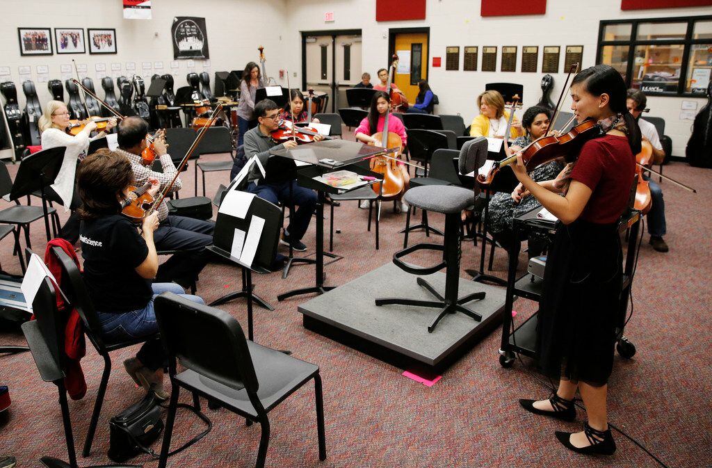 Assistant director of orchestra Victoria Lien leads a practice for parents of students at...