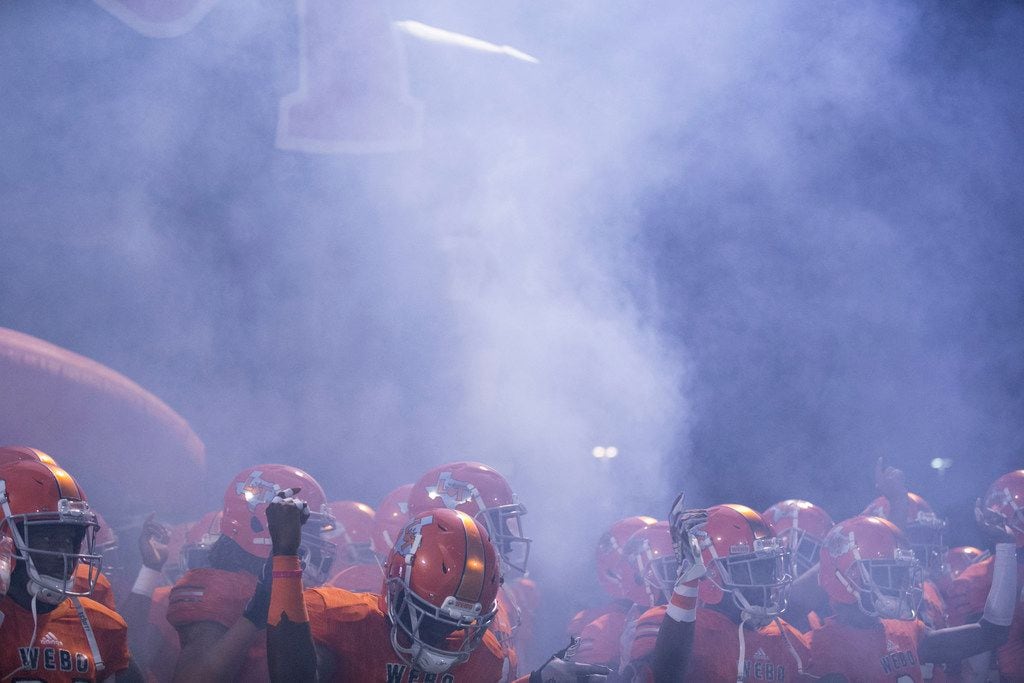 Lancaster Tigers high school football players wait in a cloud of smoke to be introduced...