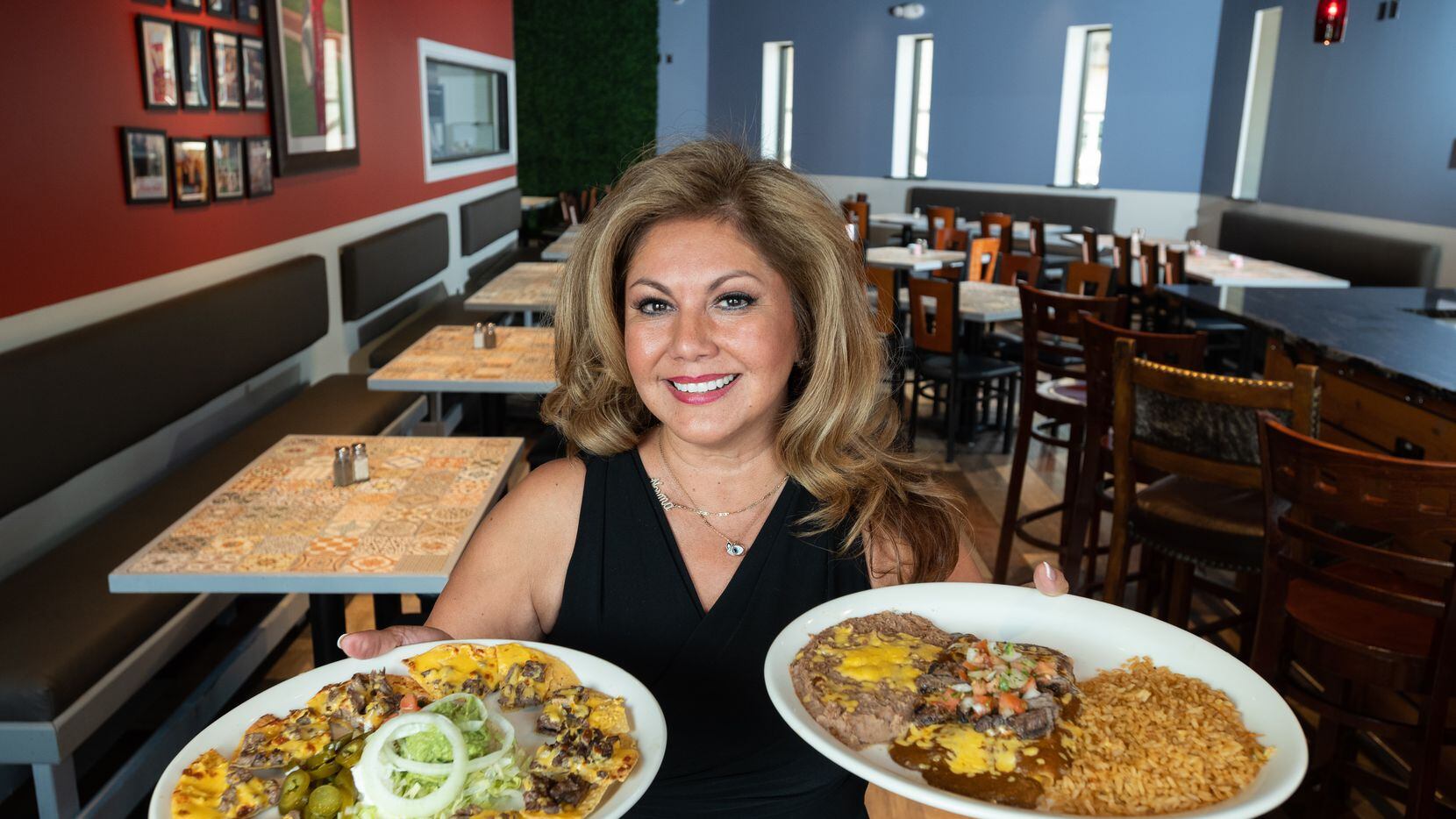 Norma Valles, co-owner of Casita Tex-Mex restaurant, holds dishes of fajita nachos, left,...