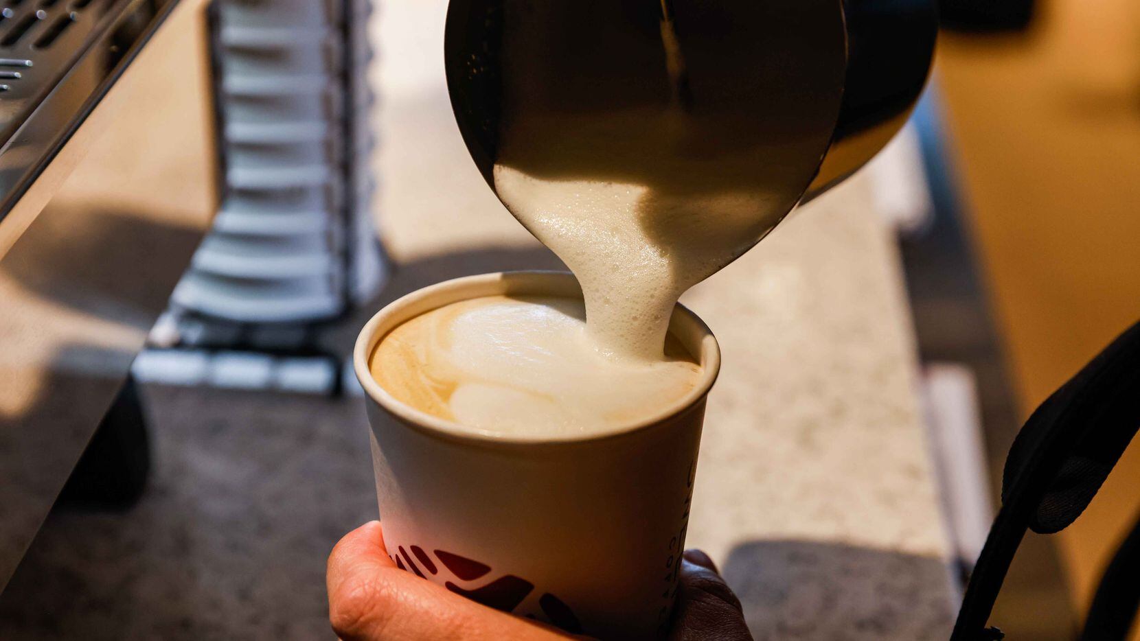 Elena Charis, an employee at Sweetwaters Coffee & Tea in Frisco, makes a latte before...