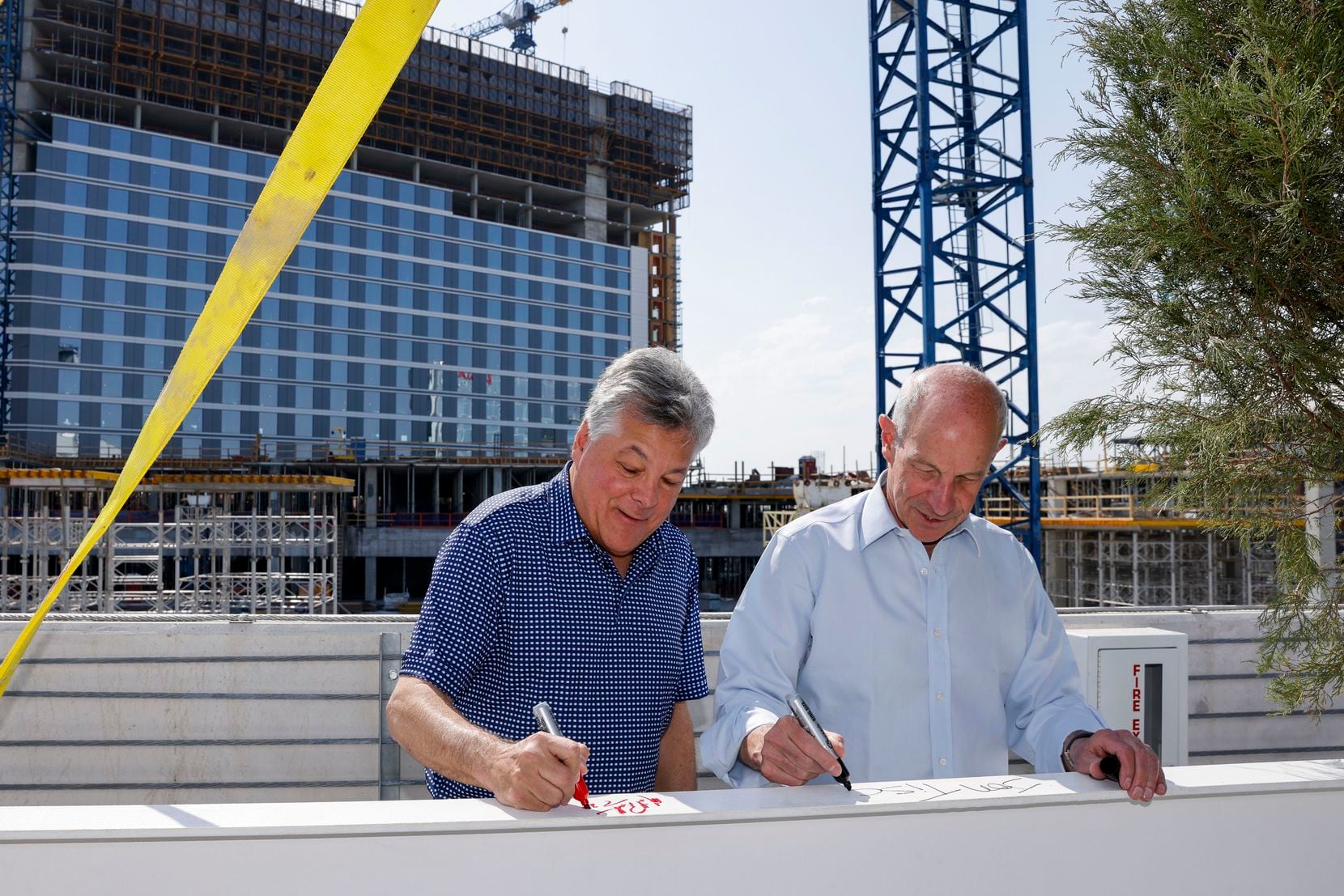 Texas Rangers co-owner Neil Leiberman (left) and Jonathan Tisch, CEO of Loews Hotels, sign a...