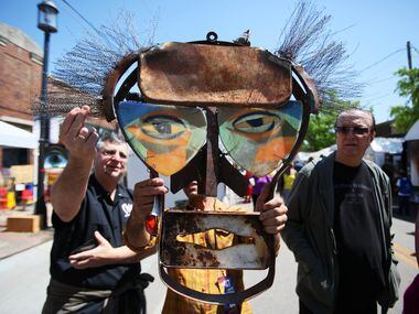Artist Mitch Berg, of Santa Fe, New Mexico, holds a piece of his own work as he attempts to...