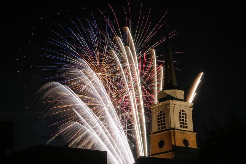 Fireworks illuminate the First Baptist Church Arlington's steeple during a Fourth of July...