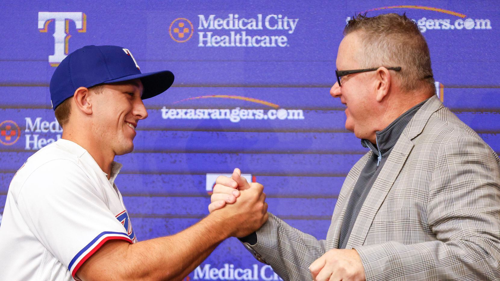 Texas Rangers top pick Wyatt Langford (left) shakes hand with Rangers Senior Director of...