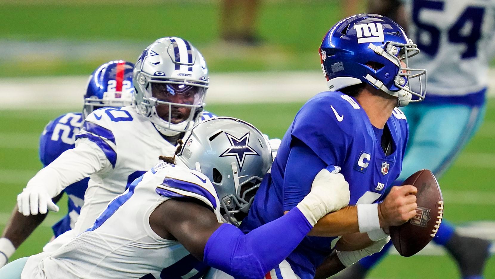 Giants quarterback Daniel Jones (8) fumbles as he is hit by Cowboys defensive end DeMarcus Lawrence (90) during the second quarter of a game on Sunday, Oct. 11, 2020, at AT&T Stadium in Arlington.