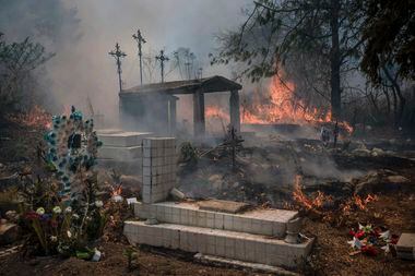 Un incendio forestal quema parte de un cementerio el lunes 25 de marzo de 2024, en Nogales,...
