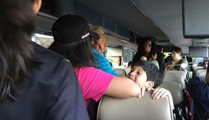 Jonas Aranda, de 4 años, observa cómo otros viajeros suben al autobús que llevará a un grupo...