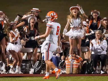 Members of the Rockwall drill team cheer quarterback Braedyn Locke (8) after he scored on a...