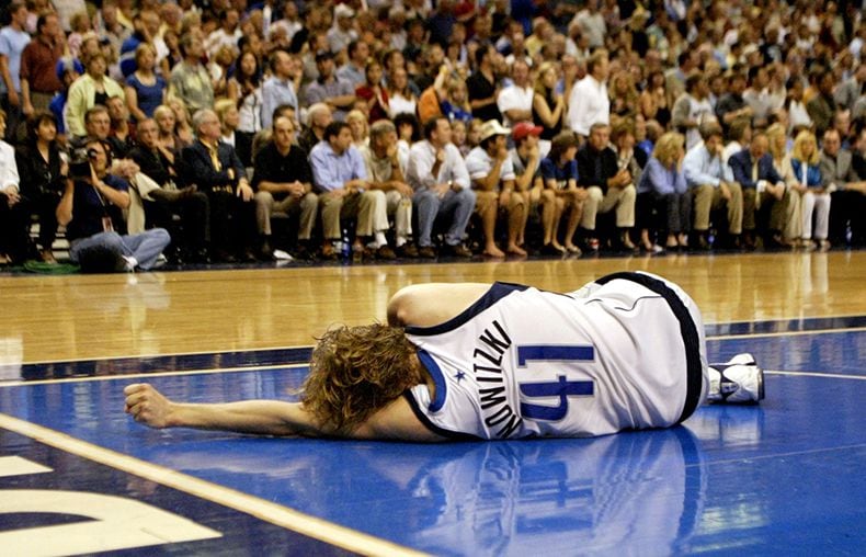  May 23, 2003--Dallas' Dirk Nowitzki lies on the floor after twisting his left knee in the...