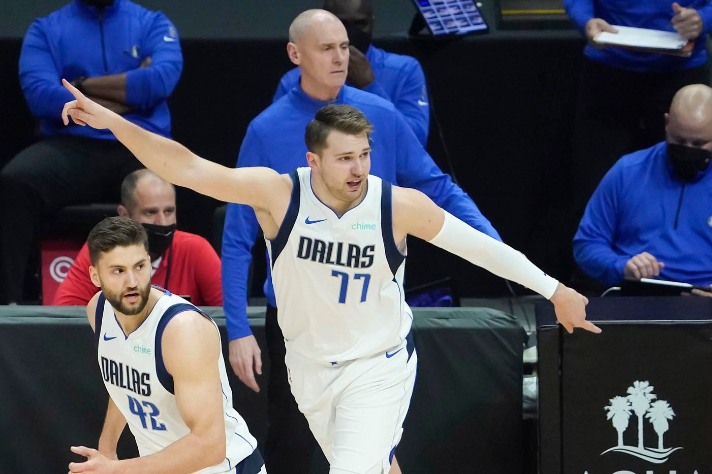 Dallas Mavericks guard Luka Doncic (77) points down court while getting back on defense with forward Maxi Kleber (42) in front of head coach Rick Carlisle during the first half of an NBA playoff basketball game against the LA Clippers at Staples Center on Tuesday, May 25, 2021, in Los Angeles.