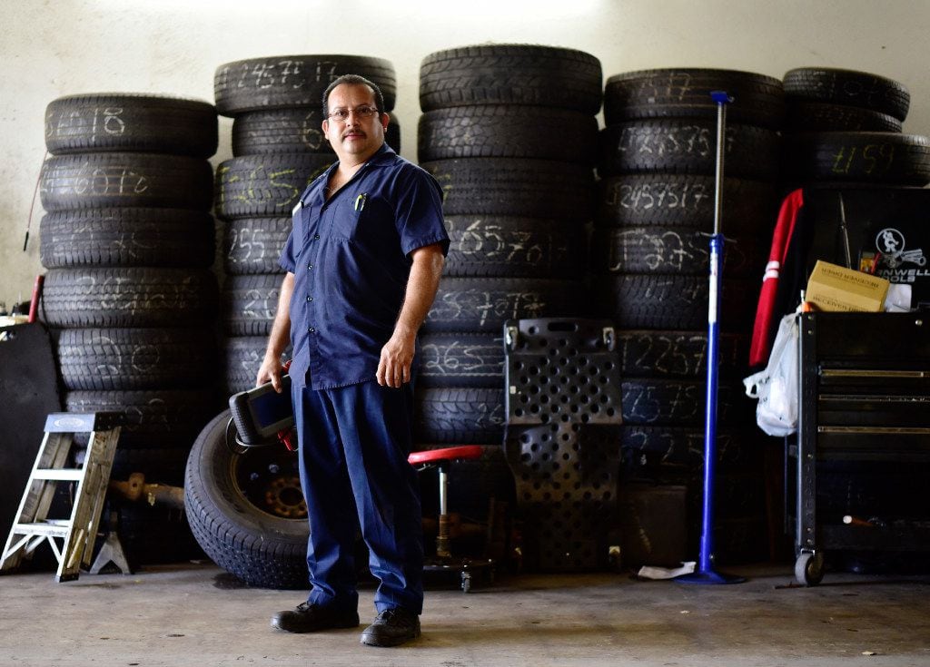 Joaquin Godinez poses at his auto mechanic shop in southeast Dallas.
