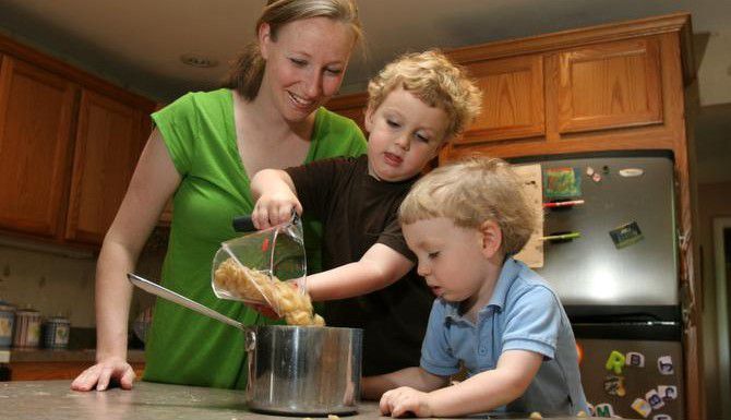 Erin Chase permite a sus hijos Ryan y Charlie preparar la pasta para la cena familiar en...